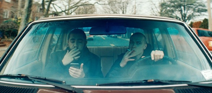 Two men smoking inside vehicle